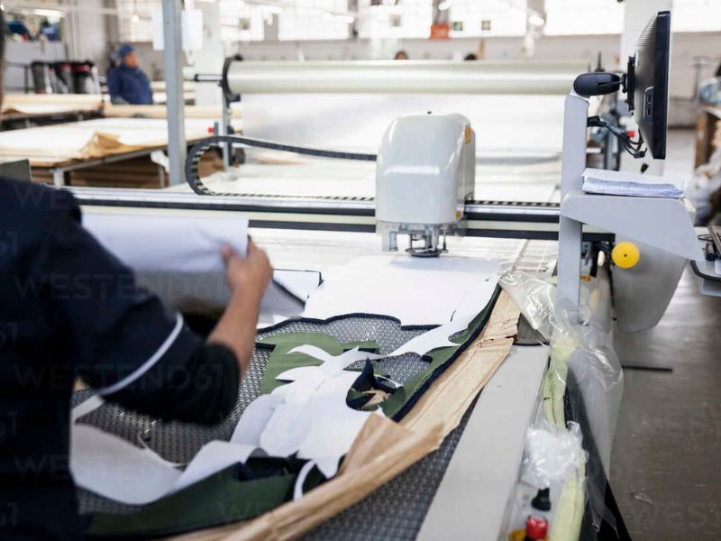 Pattern cutting in a clothing manufacturer machine cutting out pattern pieces in a factory