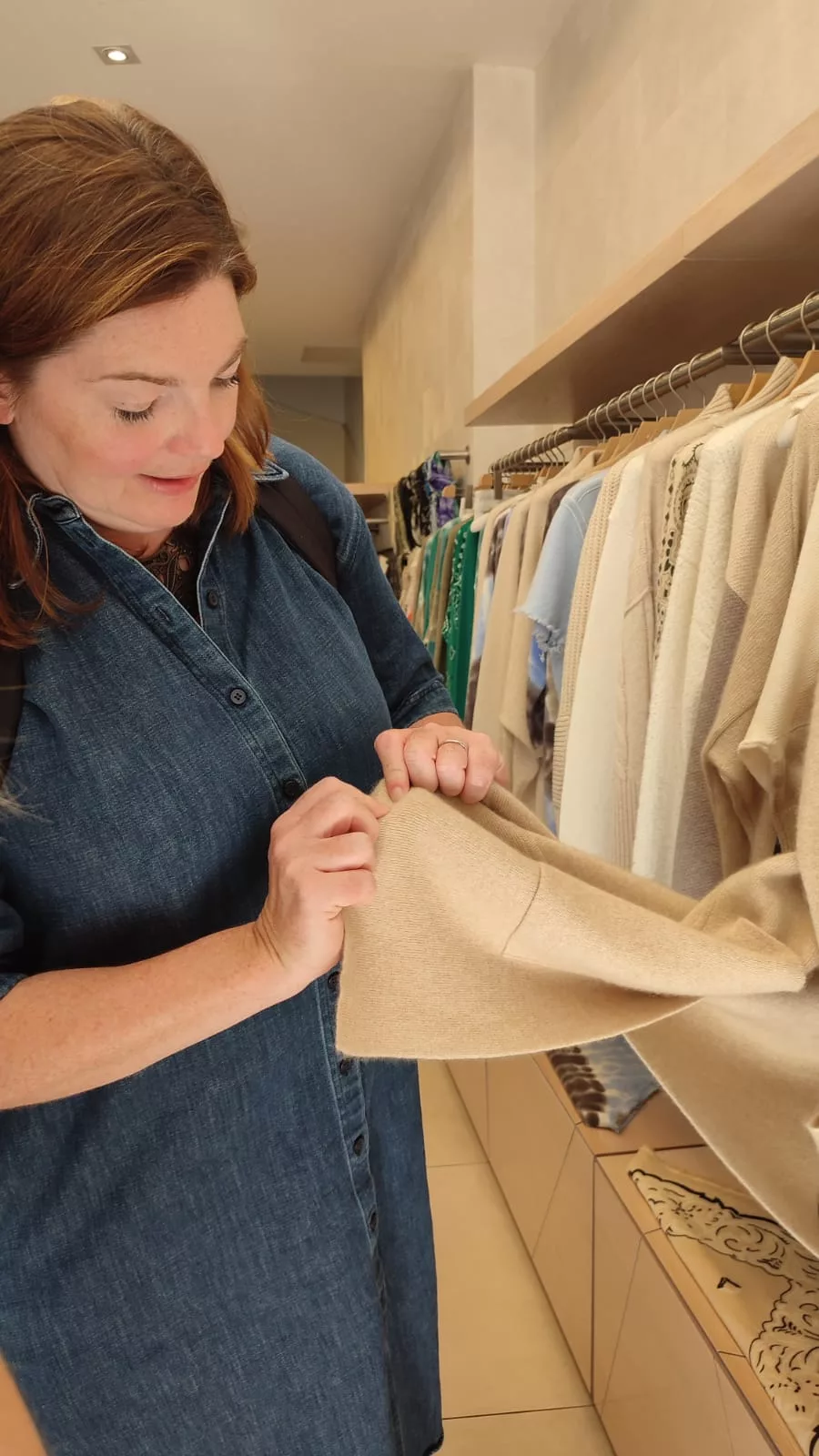 woman examining beige cashmere